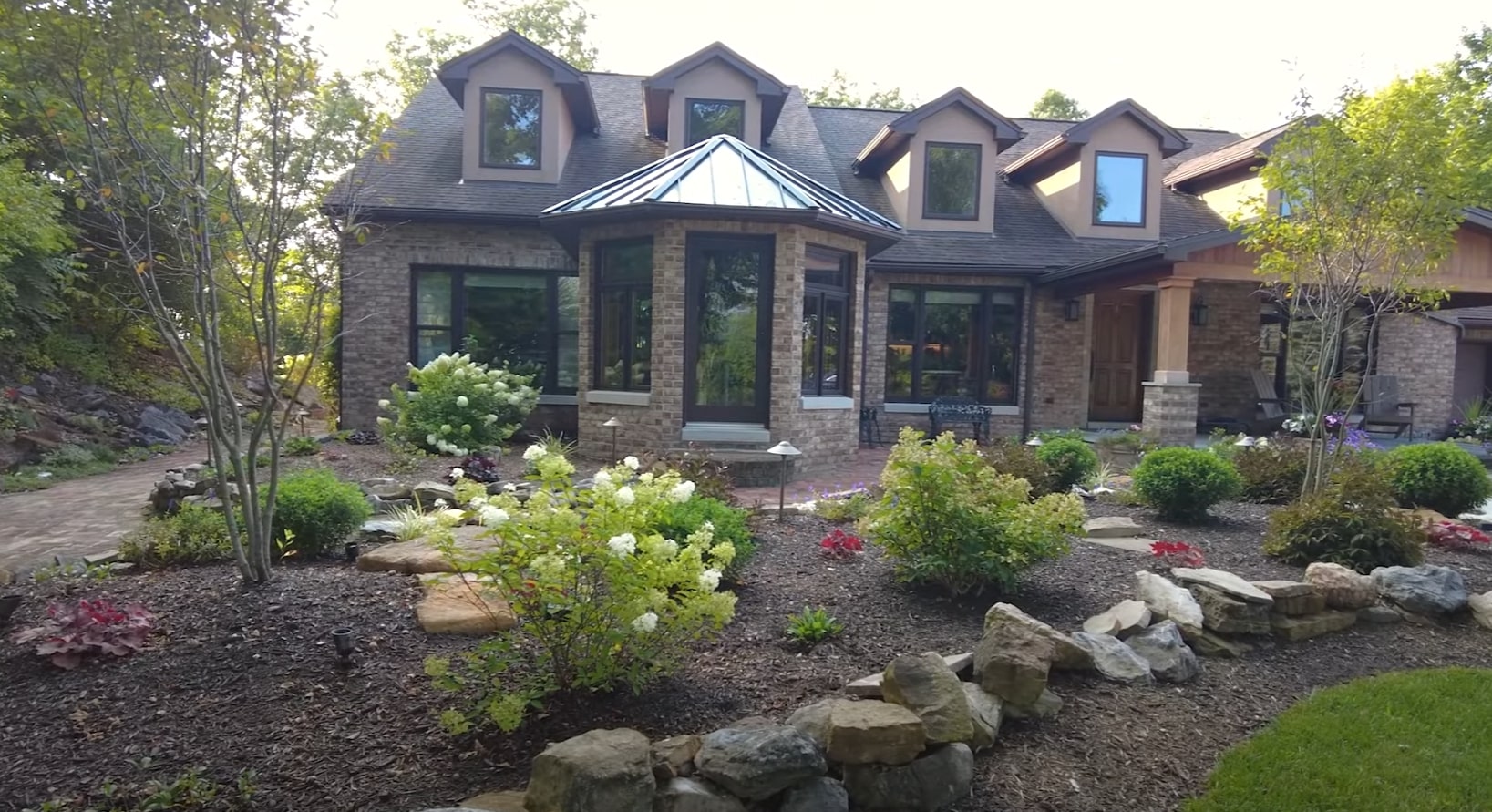 Professional Front Yard Landscaping - Curb Appeal Enhancement Beautifully landscaped front yard featuring natural stone elements and diverse plantings