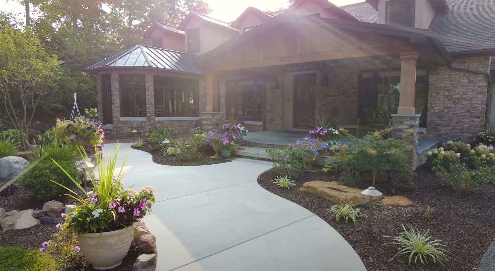 Front Yard Transformation - Lighting Design and Seasonal Plantings Elegant front yard design with curved driveway, landscape lighting, and seasonal plantings